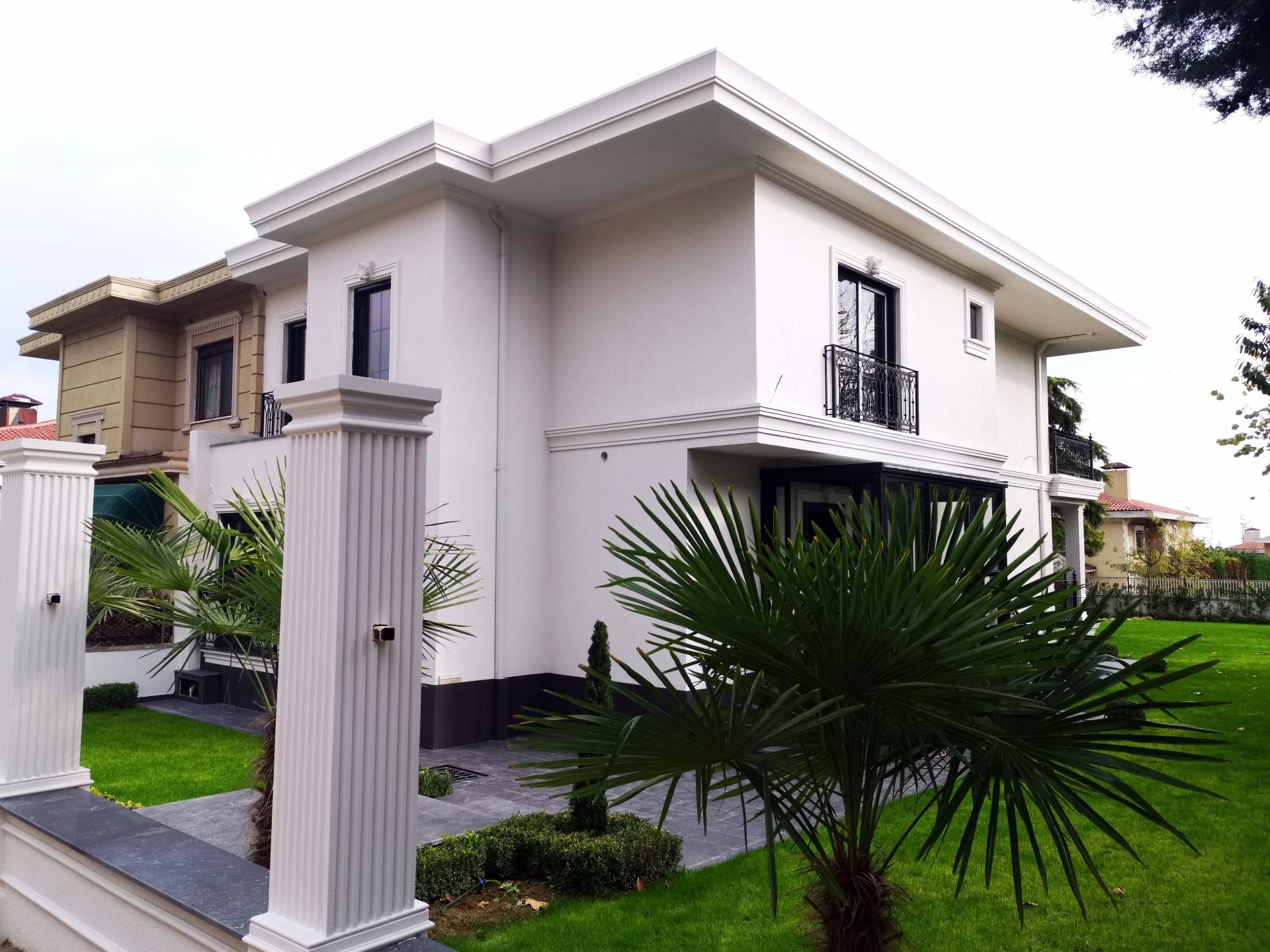 İki katlı beyaz villa dış cephesinde poliüretan söve, kat silmesi ve yivli bahçe sütunu uygulaması