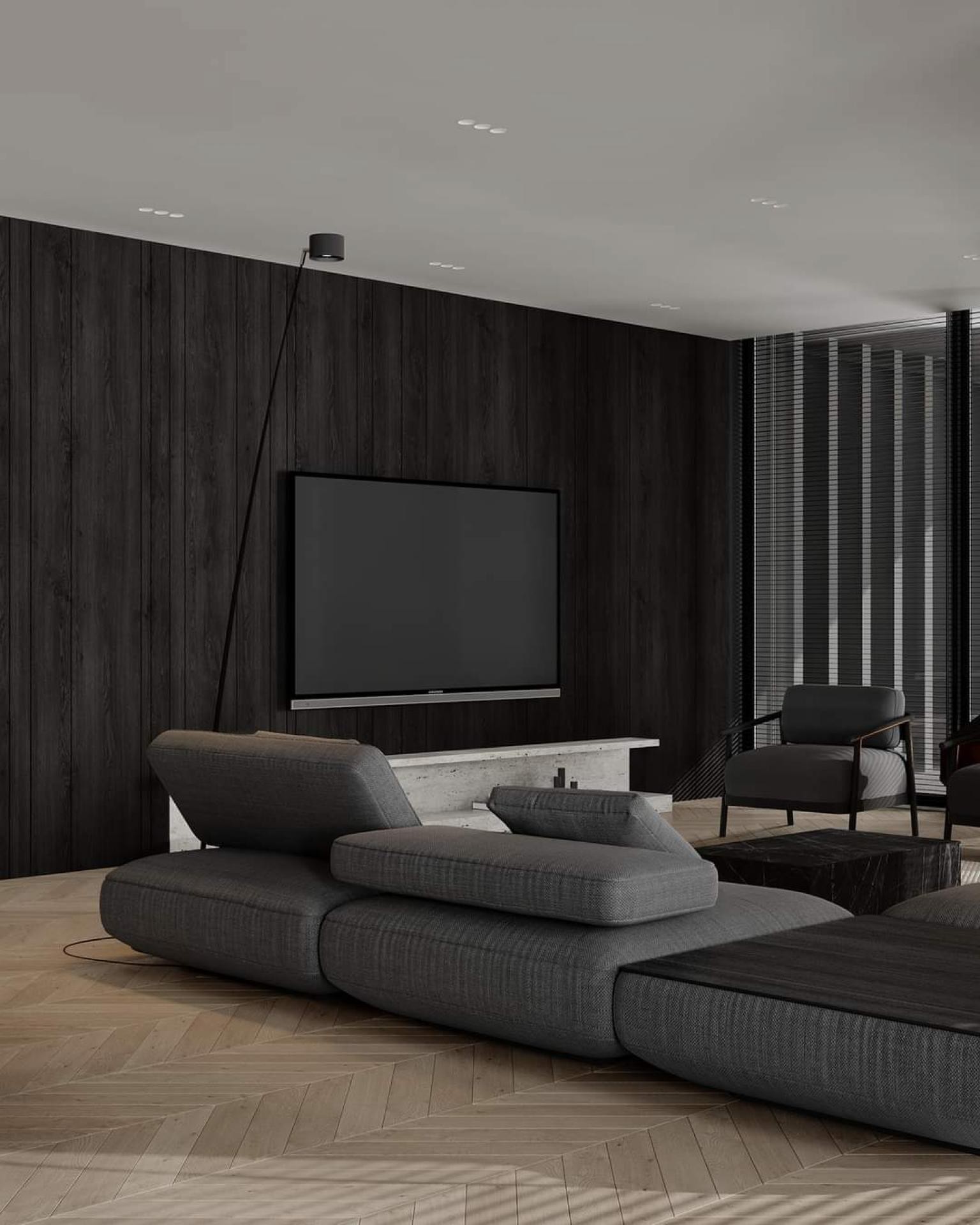 Siyah dikey ahşap panellerle kaplı TV duvarı, traverten TV konsolu, modüler gri koltuk ve balıksırtı parkeli minimalist salon.