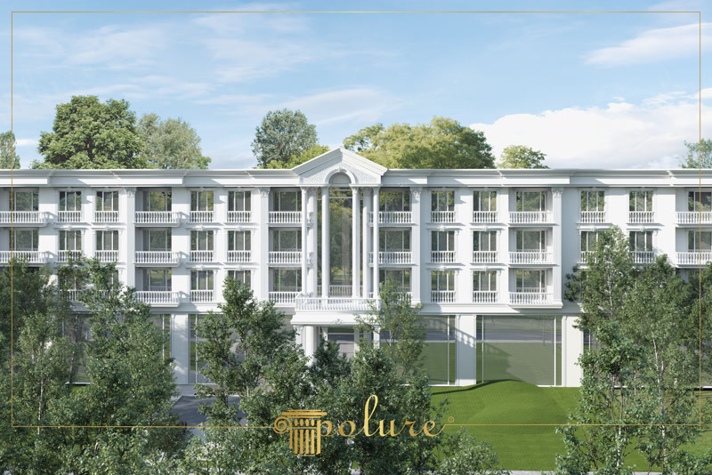 Üçgen alınlık, yüksek sütunlar ve balustradlı pencere söveleri ile tasarlanmış geniş otel ve rezidans dış cephesi.