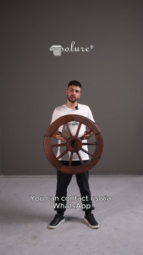Rustik tekerlek dekoru sunucunun elinde göbek ve çubuk ayrıntılarıyla sergileniyor