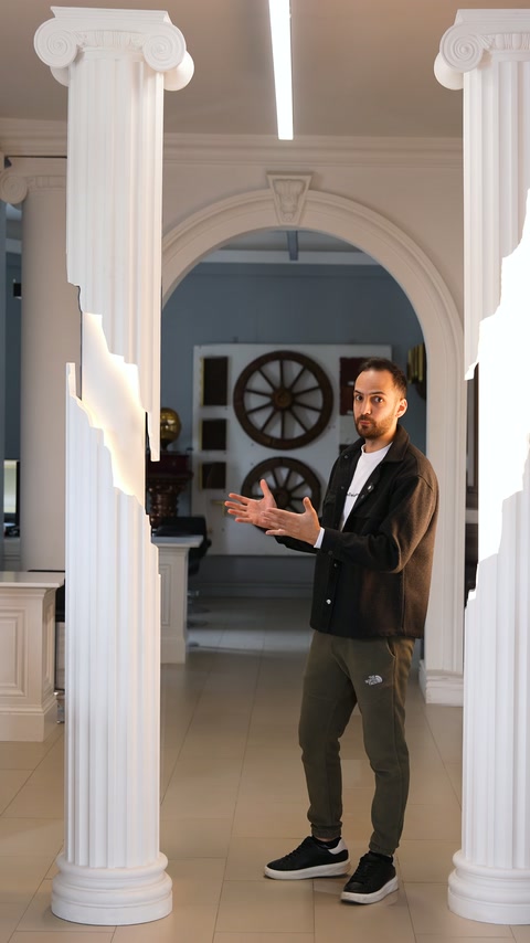 Kemerli iç mekânda sunucu, iki yivli sütunun arasında duruyor