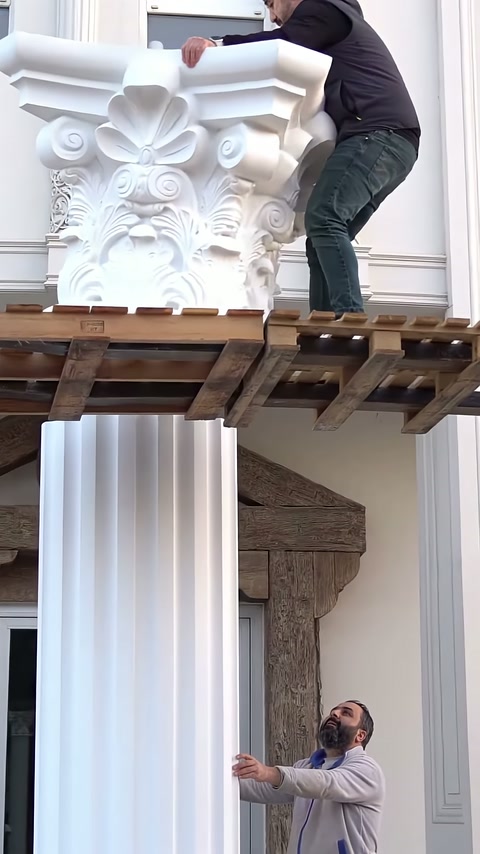 Ustalar ahşap platformdan bezemeli başlığı sütunun tepesine kaldırıyor