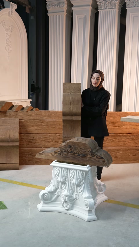 Sunucu, kalın gövdeli konsolu sütun örnekleri önünde anlatıyor.