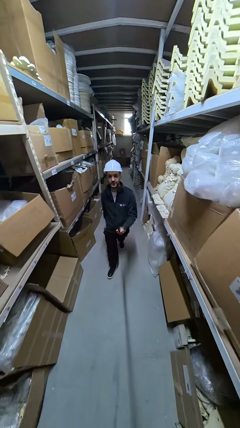 Depo rafları boyunca kutulanmış profiller ve dekoratif parçalar uzanıyor