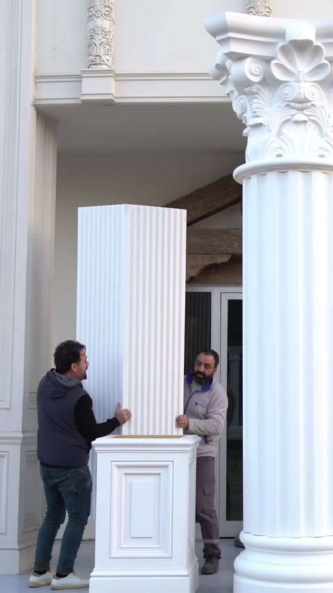 İki usta farklı biçimlerdeki yivli sütun gövdelerini konumlandırıyor.