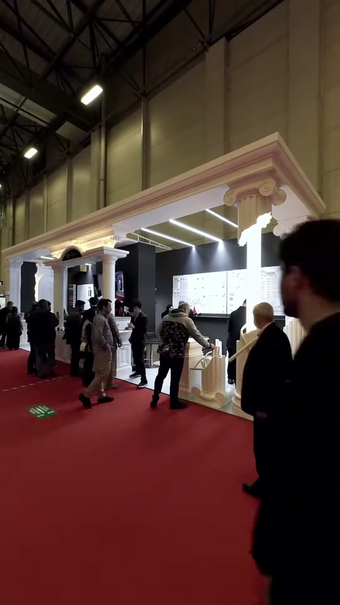 Klasik sütunlu cephe düzeni kalabalık fuar koridoruna açılıyor