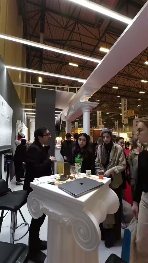 Ziyaretçi grubu işlemeli banko önünde sütun modellerini değerlendiriyor