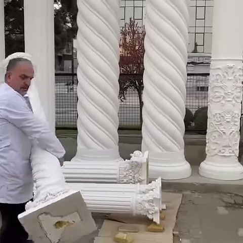 Uzun dekoratif sütun parçası yatay biçimde elde taşınıyor