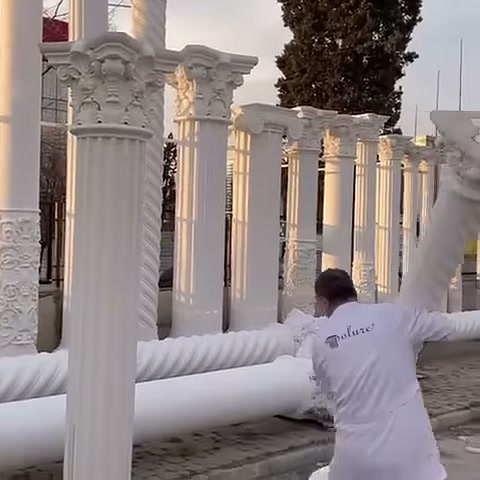 Usta, yatay dekoratif parçayı sergi alanının diğer tarafına götürüyor