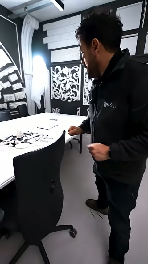 Siyah duvar önündeki masada minyatür numuneler düzenleniyor.