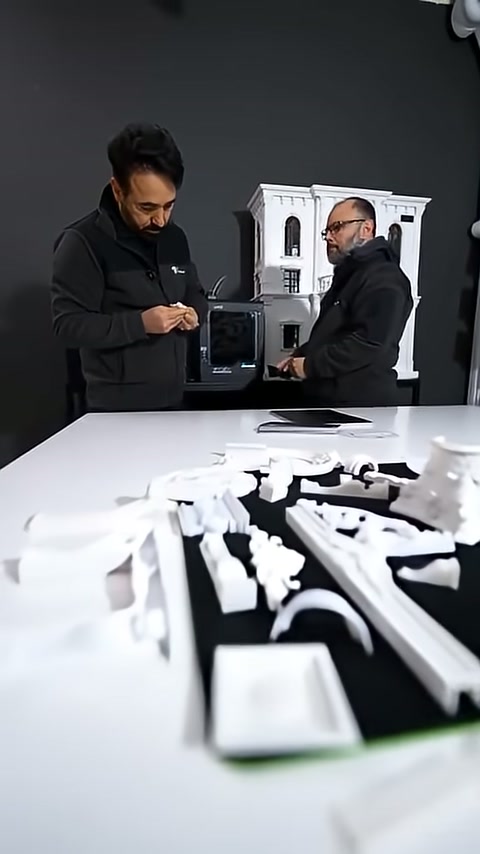 Görevli elindeki küçük parçayı cephe maketi önünde tanıtıyor.