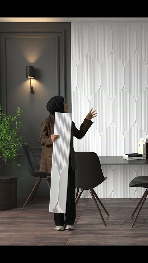 Uzun dekoratif panel tutulurken arkadaki geometrik duvar kaplaması işaret ediliyor.
