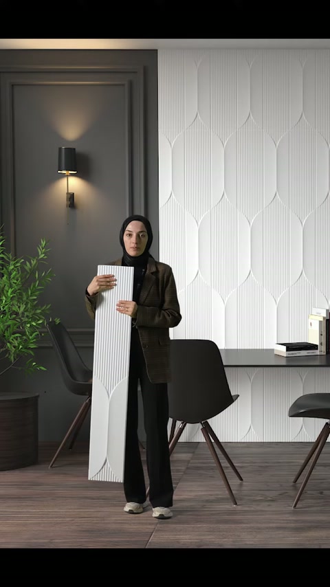 Oluklu beyaz panel, modern masa ve geometrik kaplama önünde inceleniyor.
