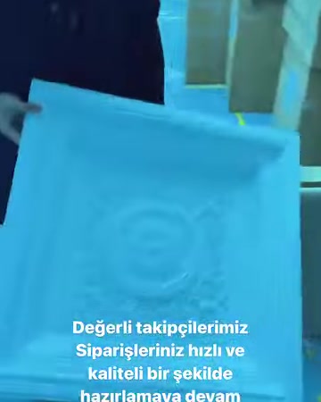 Kare formdaki kabartmalı tavan dekoru elde inceleniyor.