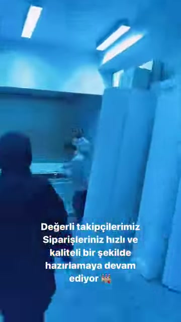 Görevli, dik duran büyük kalıpların yanından üretim alanına geçiyor.