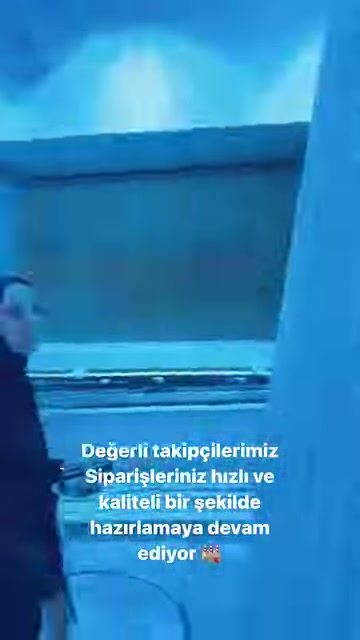 Görevli, raf sistemindeki uzun poliüretan parçaları işaret ederek tanıtıyor.