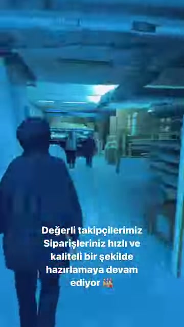 Görevli, kalıp ve ürünlerle dolu geniş atölye koridorunda yürüyor.