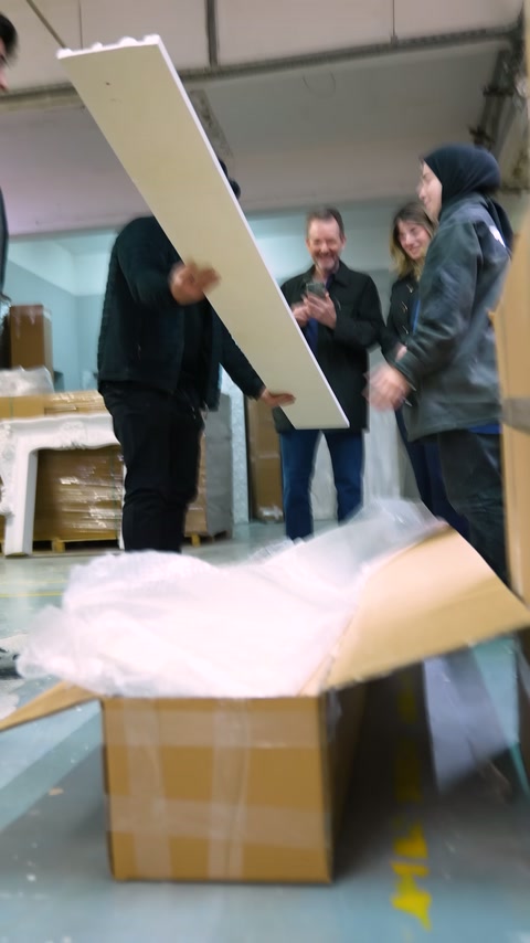 Geniş beyaz dekoratif panel, ambalajından çıkarılarak dik biçimde tutuluyor.