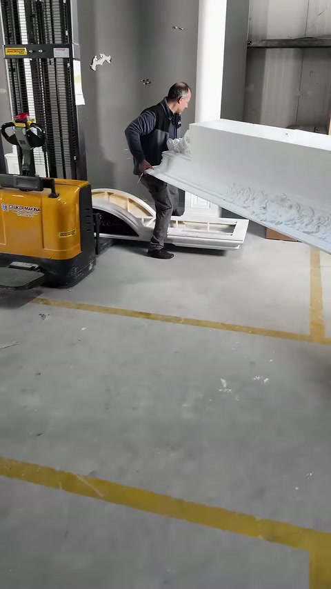 Usta, uzun kabartmalı taç elemanını zeminden kaldırarak taşıyor.