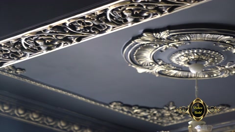 Siyah tavan yüzeyini çevreleyen altın kabartmalı kartonpiyer tamamlanmış halde duruyor
