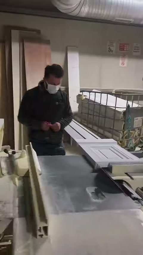Usta, geometrik desenli söve parçasını kesim öncesinde kontrol ediyor.