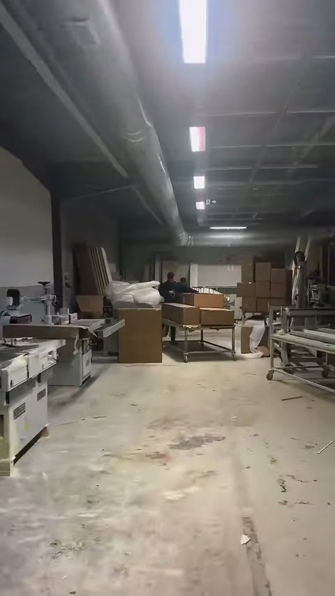 Atölye koridorunun sonunda çalışma ekipmanları ve karton kutular bulunuyor.