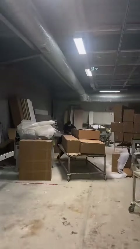 Karton kutular, paketlenmiş parçalar ve üretim masaları alanda görülüyor.