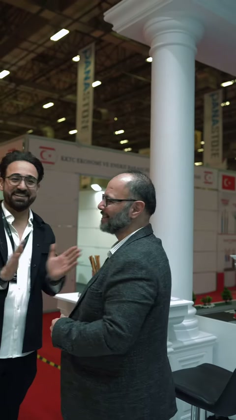 Stand görevlisi, ziyaretçiye dekoratif cephe ürünleri hakkında bilgi veriyor