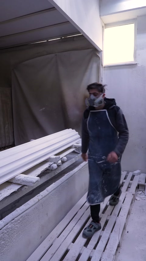 Koruyucu ekipmanlı çalışan beyaz profillere püskürtme boya uyguluyor