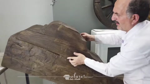 Geniş ahşap dokulu kütük parçası iki elle sergileniyor