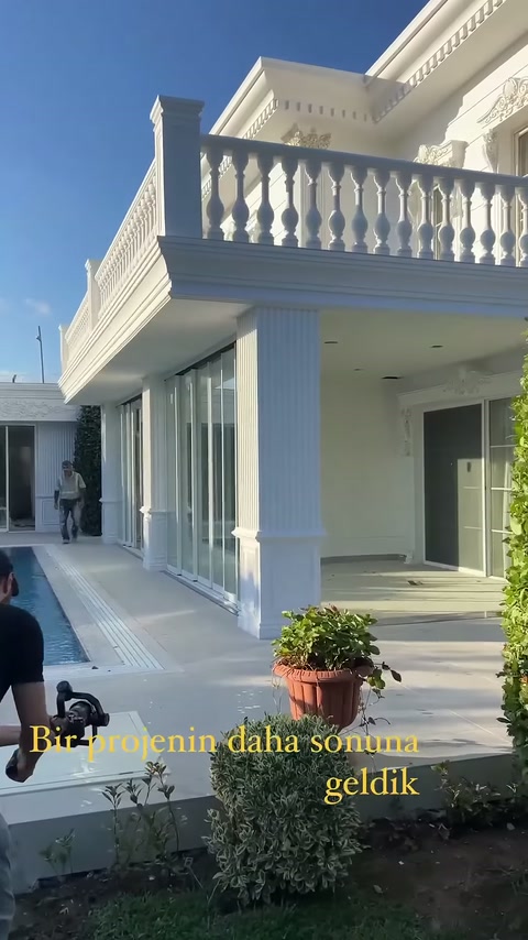 Villa terasında yivli sütunlar, balkon korkulukları ve saçak profilleri görüntüleniyor.