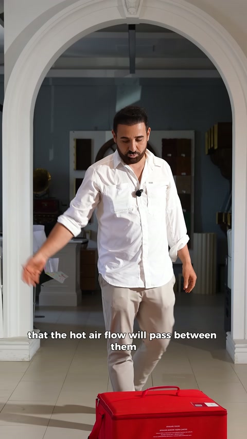 Sunucu zemindeki kırmızı çantayı eliyle işaret ederek açıklıyor.