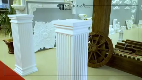 İki kısa beyaz sütun ahşap tekerlek dekorunun önünde bulunuyor