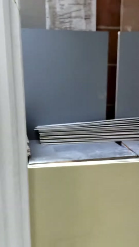 Kesilmiş dikdörtgen levhalar atölyedeki dolap üzerinde yatay istiflenmiş.