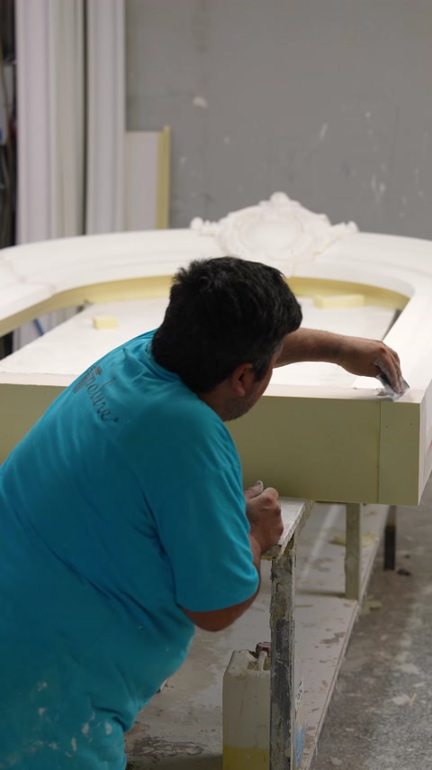 Usta, çerçevenin tepe süslemesini yerleştirerek birleşimi kontrol ediyor.