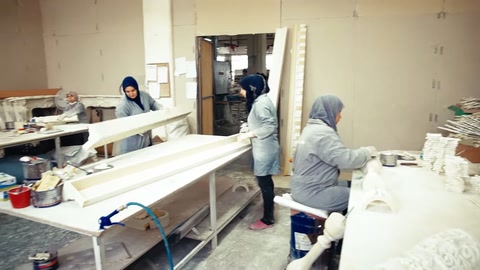 Çalışan, geniş beyaz yüzeye elindeki aletle müdahale ediyor.