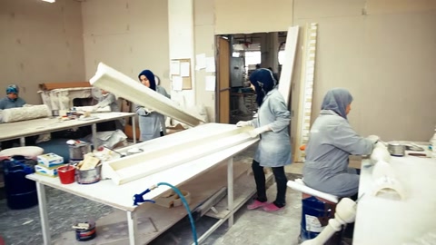 Uzun profiller ve büyük kalıplar çevresinde atölye çalışması sürüyor.
