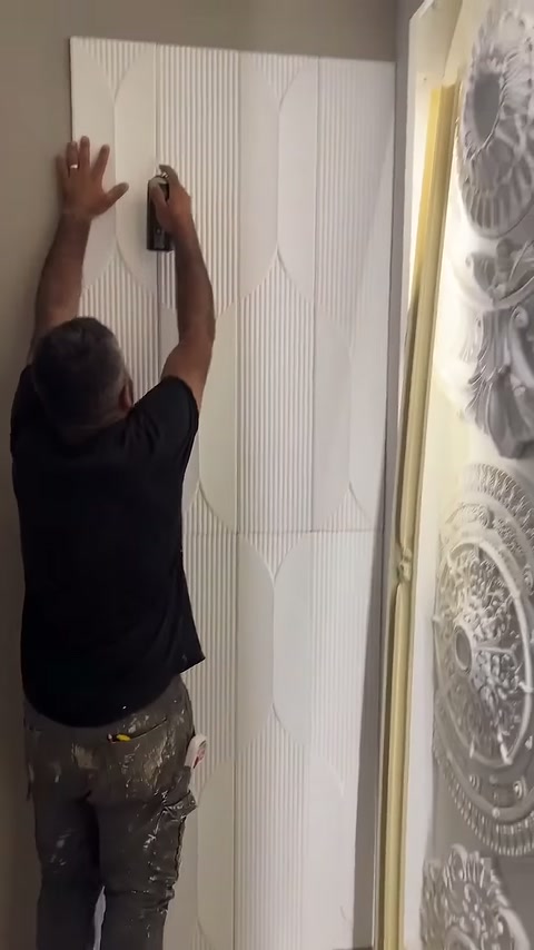 Usta dikey çizgili kaplamanın üst bölümünde kenar ayarı yapıyor.