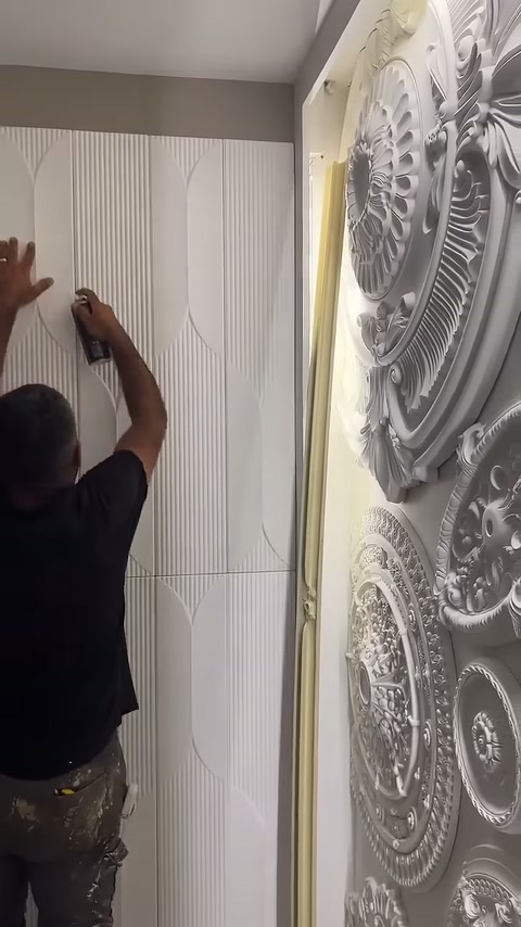 Montajcı üst köşedeki panel kenarını eli ve spreyle sabitliyor.