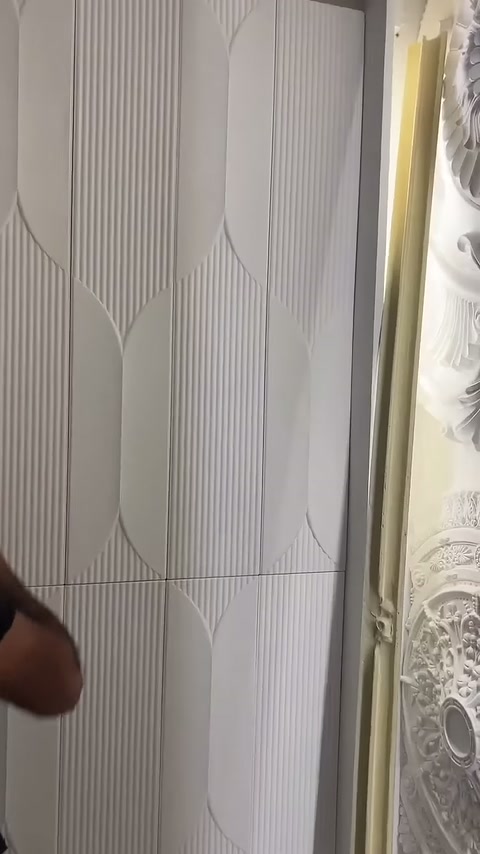 Tamamlanan beyaz 3D panel düzeni duvar boyunca görüntüleniyor.