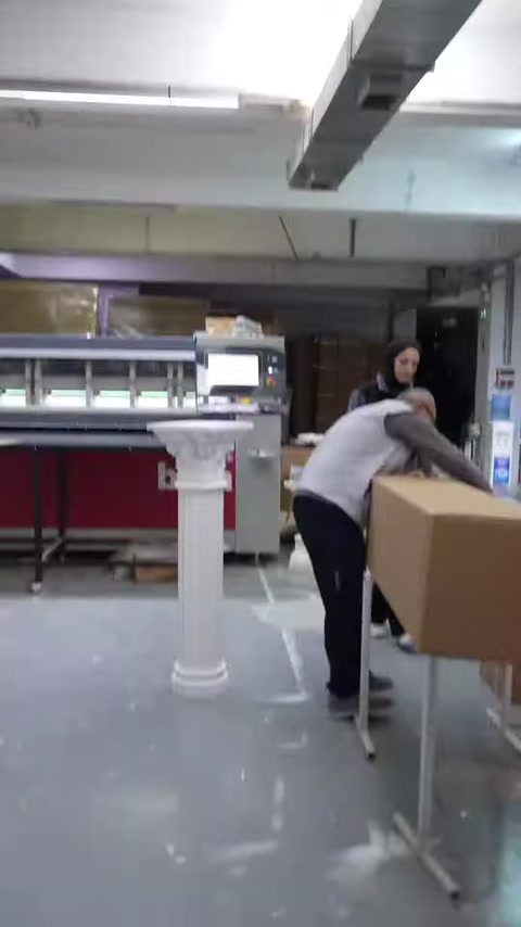 Dekoratif kısa sütun, hazırlanan büyük karton kutunun yanında bekliyor