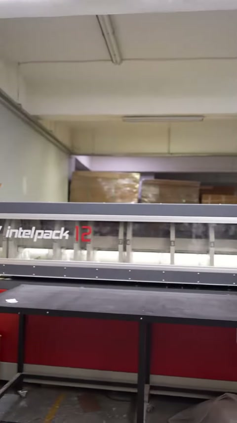 Paketleme makinesinin uzun çalışma bölümü ve kontrol paneli gösteriliyor