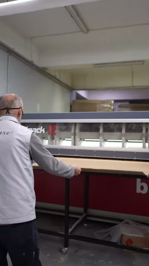Operatör paketleme hattına uzanırken sütun gövdesi önde bekliyor