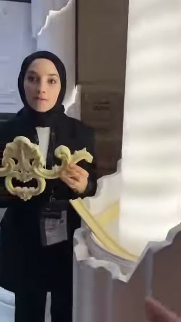Dekoratif motif, sütun tabanı yakınında iki elle açık tutuluyor