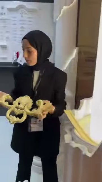 Poliüretan motif, fuar standındaki mimari numuneler arasında elde tutuluyor