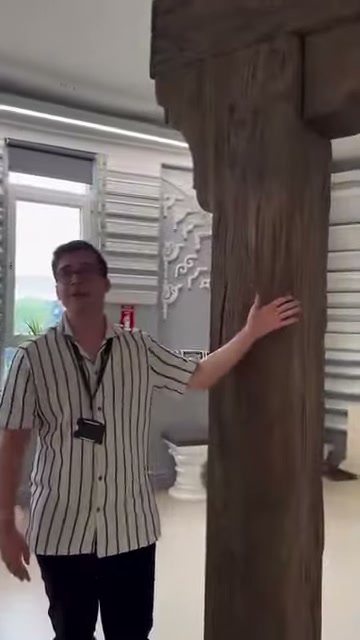 Görevli ahşap görünümü verilmiş dikey ürünün ön yüzeyine dokunuyor