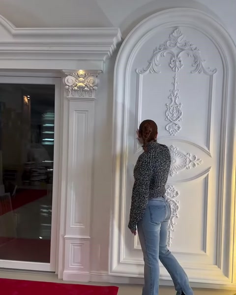 Yoğun işlemeli kemerli kapı çevresi klasik duvar panelleriyle tamamlanıyor