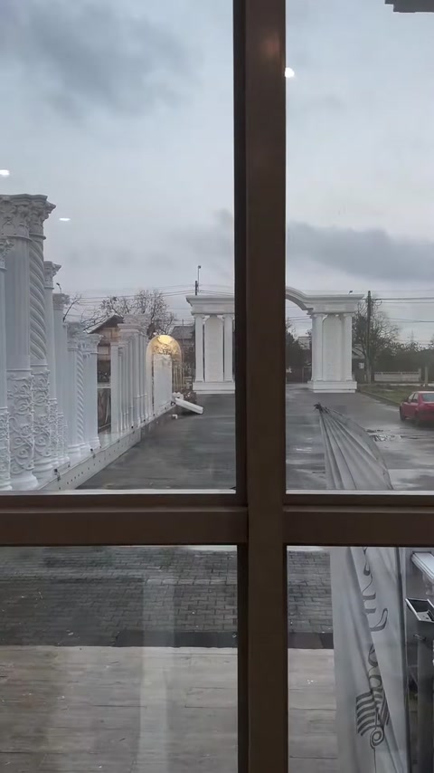 Pencere önünden dış mekândaki dekoratif sütun dizisi görülüyor