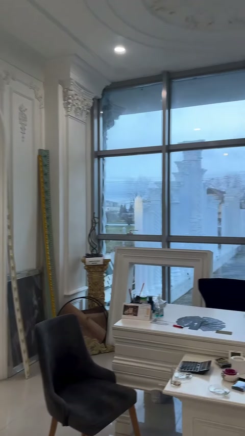Sergi ofisinde panelli duvar, masa ve geniş pencereler yer alıyor