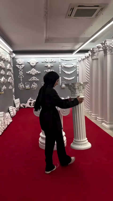 Tanıtıcı, dik konumdaki ince sütunun yerleşimini elleriyle kontrol ediyor.